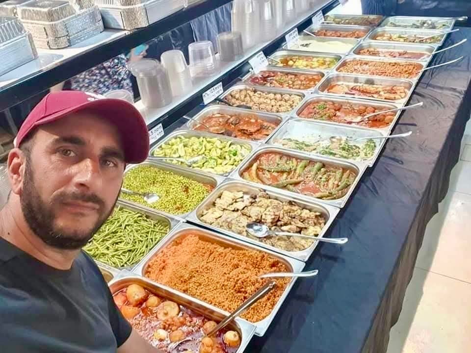 קובי ואנונו ליד מגשי אוכל שנאספו לחלוקה למשפחות באופקים