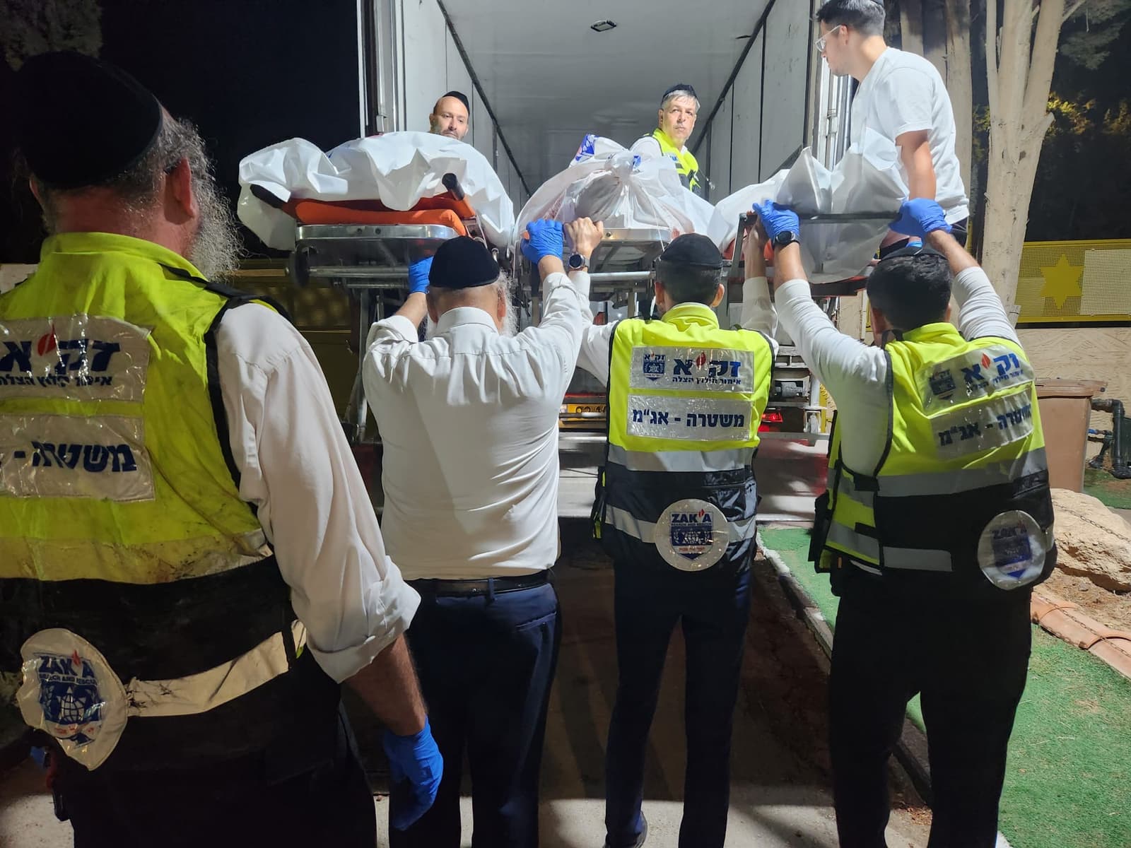 מתנדבי זק״א נושאים את הנופלים בבית העלמין באופקים אחרי השבעה באוקטובר