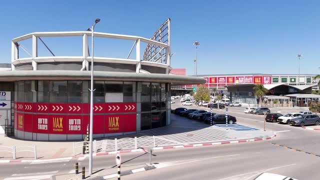 סניף מקס סטוק במרכז מסחרי, עם חניון ושילוט הרשת על חזית המבנה