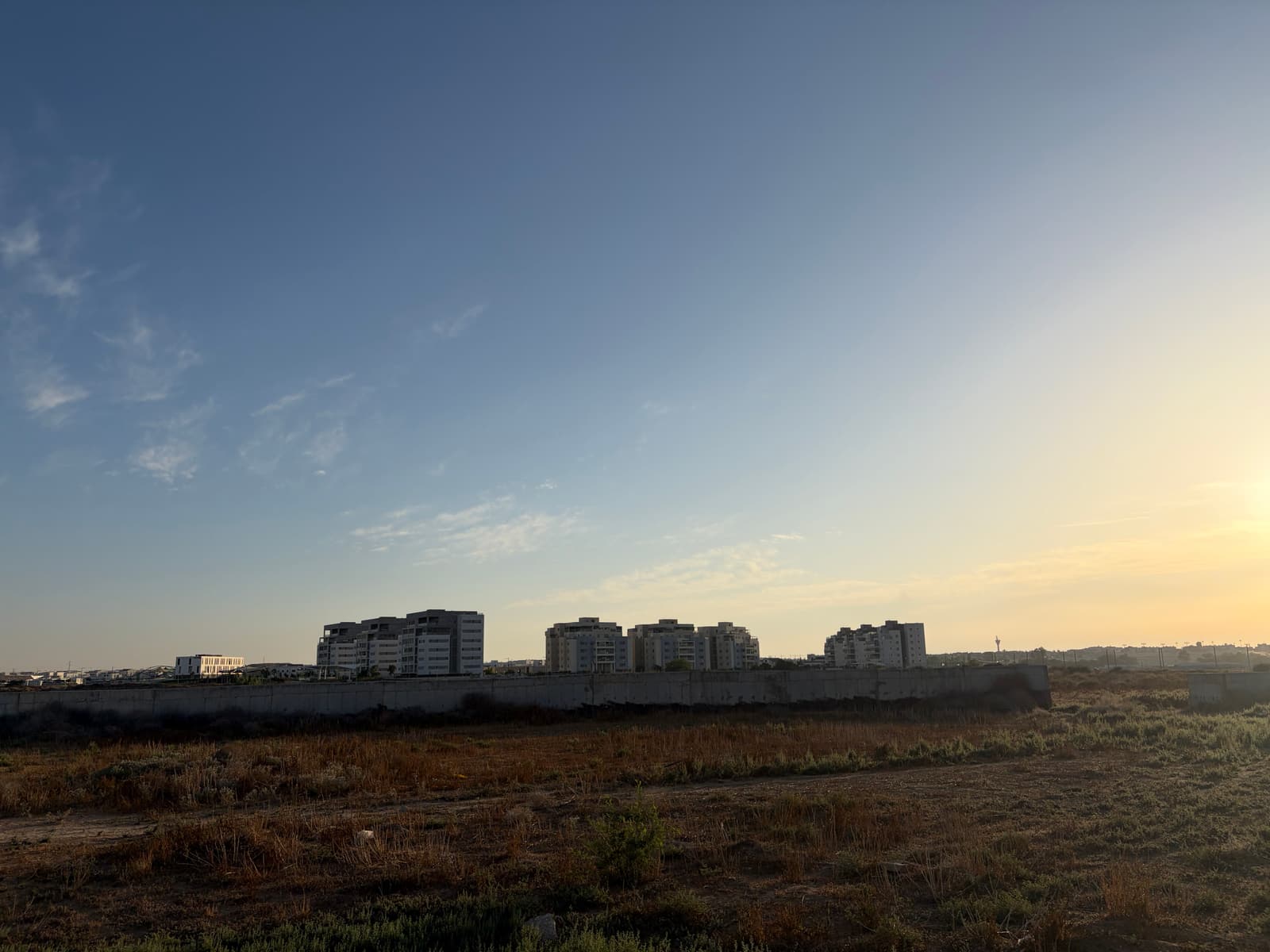 מבט מערוץ נחל אופקים אל הבנייה החדשה בשכונת אפיקי נחל בשעת שקיעה